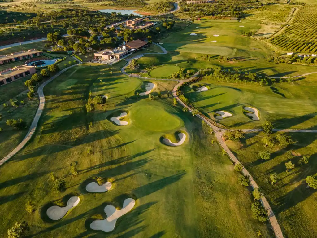 Morgado Golf med 18-green ombäddad av bunkrar i solnedgång